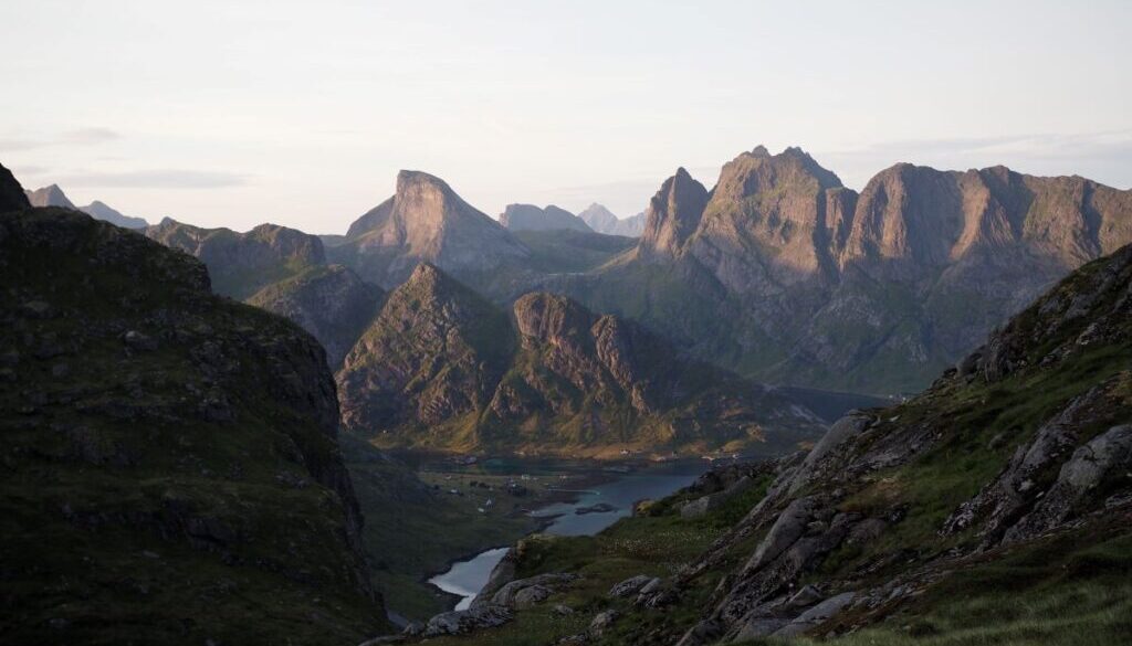 The sun going down on and illuminating the mountains surrouding forsfjord and reinefjord