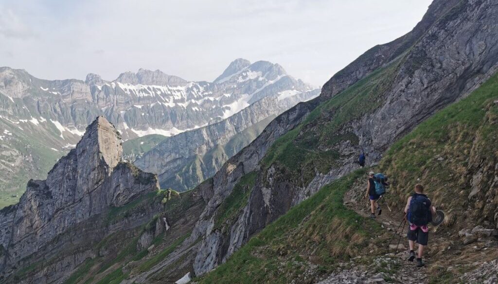 A group of friends hiking along the amazing geological limestone outcrops around säntis in appenzell, switzerland.